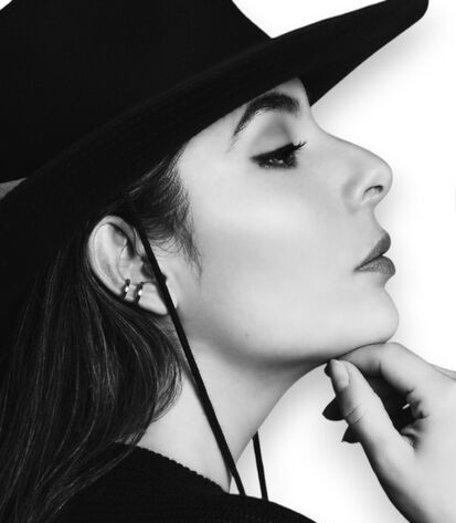 Black and white woman in profile wears a double cuff earring in silver
